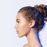 womens curly hair in messy bun hairdo