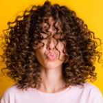 women's shoulder length curly curtain bangs hairstyle